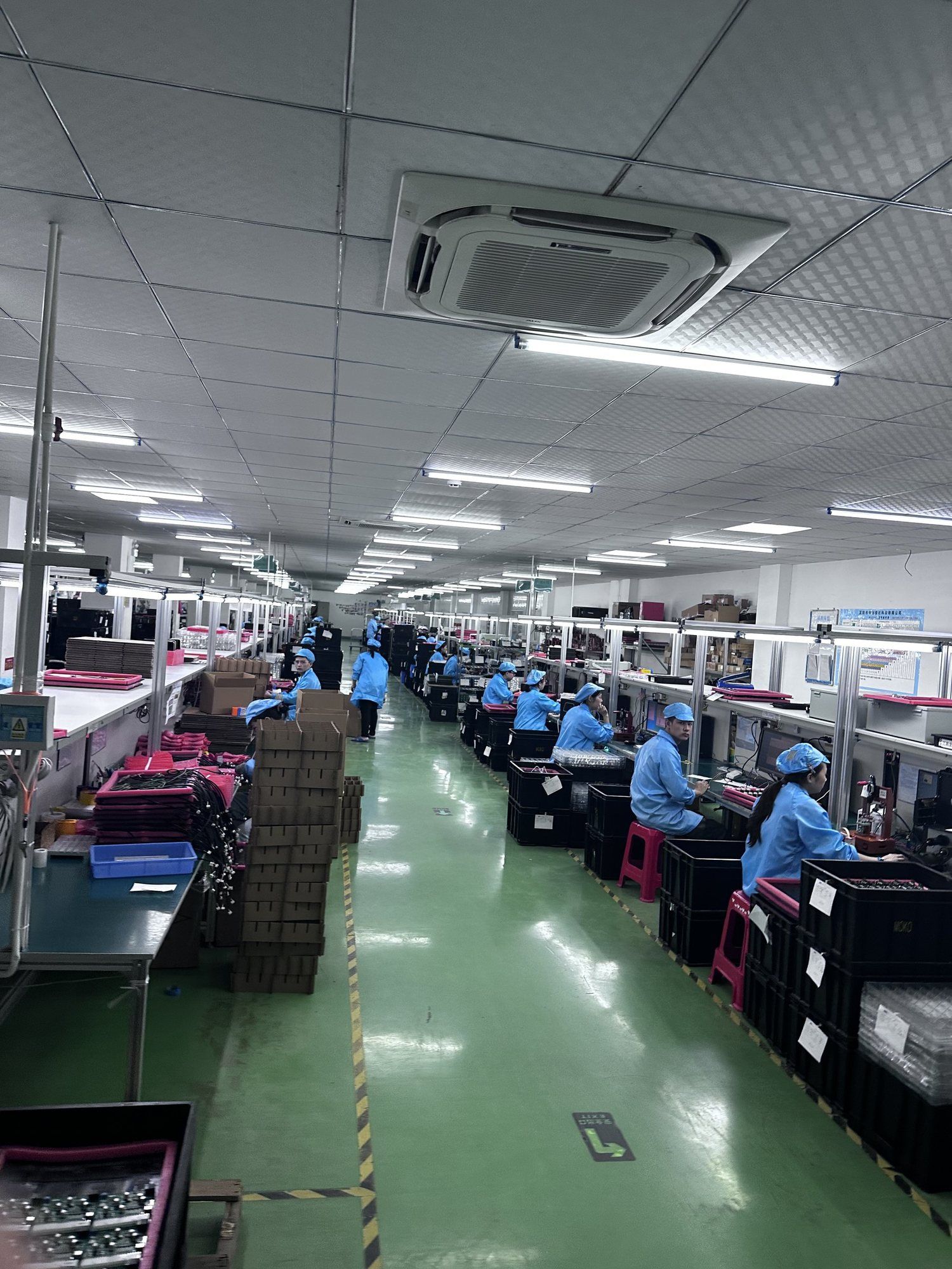 A long assembly line with workers at stations on both sides.