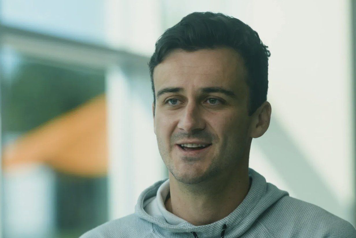 Curtis Kennedy, mid-conversation, in a grey hoodie.