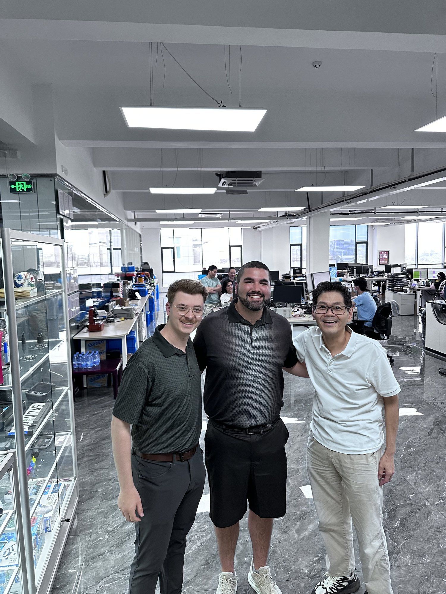 Curtis with two founders on an electronics factory floor.