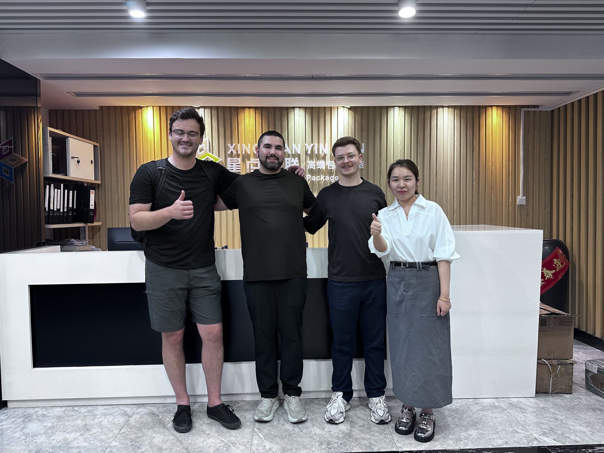 Curtis and two founders with a factory representative in a showroom lobby.