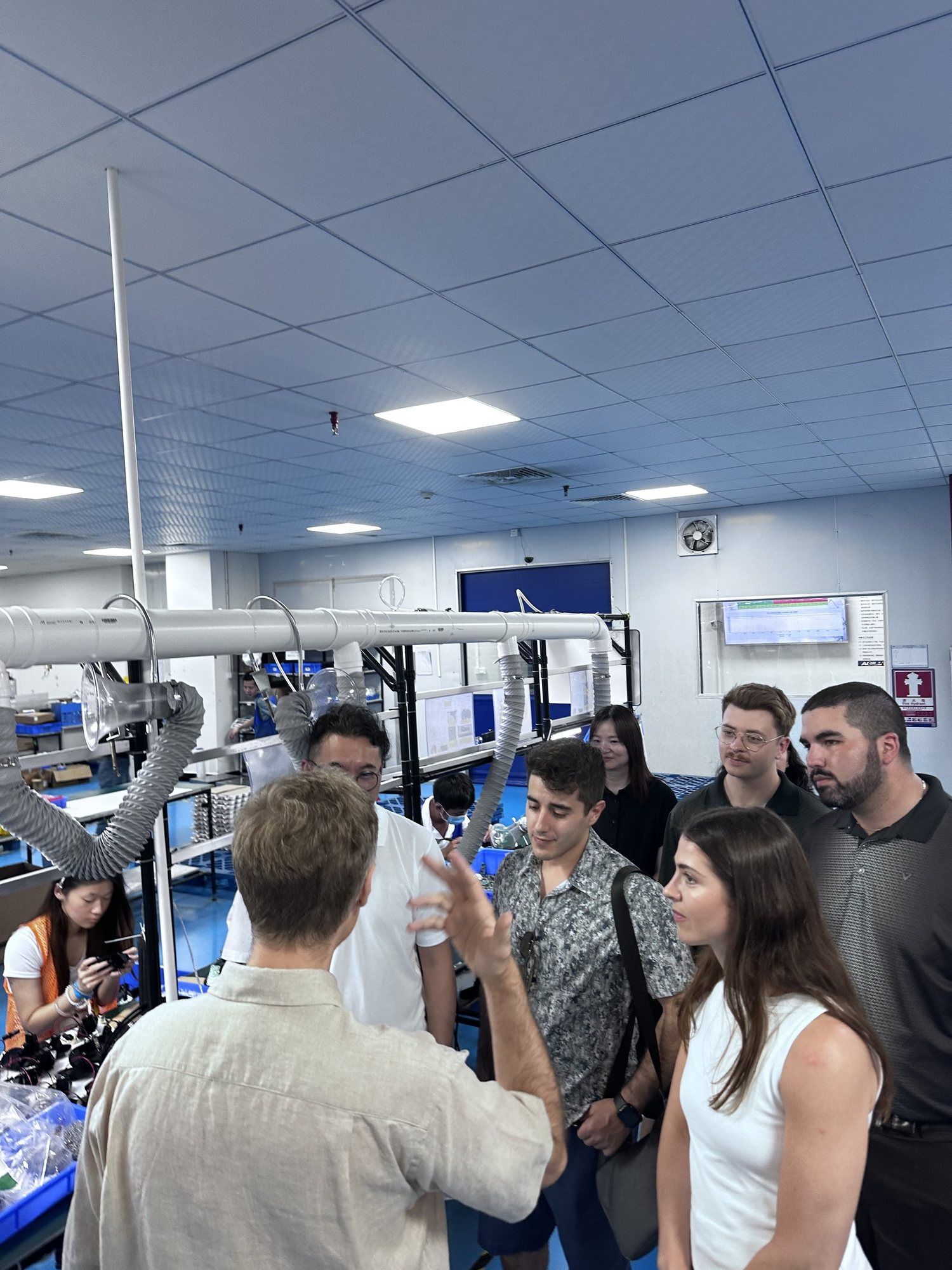 A group of founders listening to a guide on an assembly line tour.