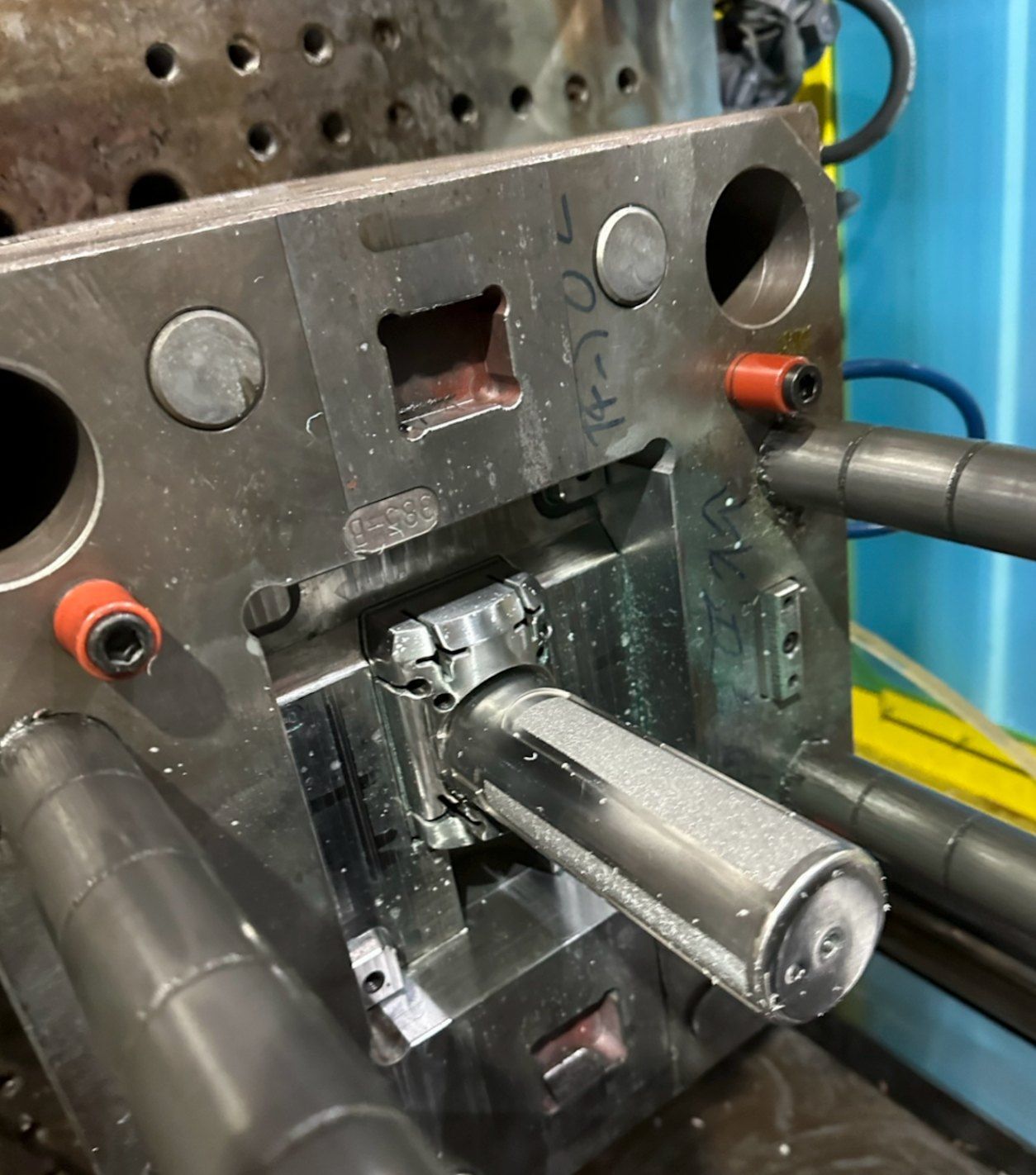 A steel injection mould core mounted in a moulding press, with a part on it.