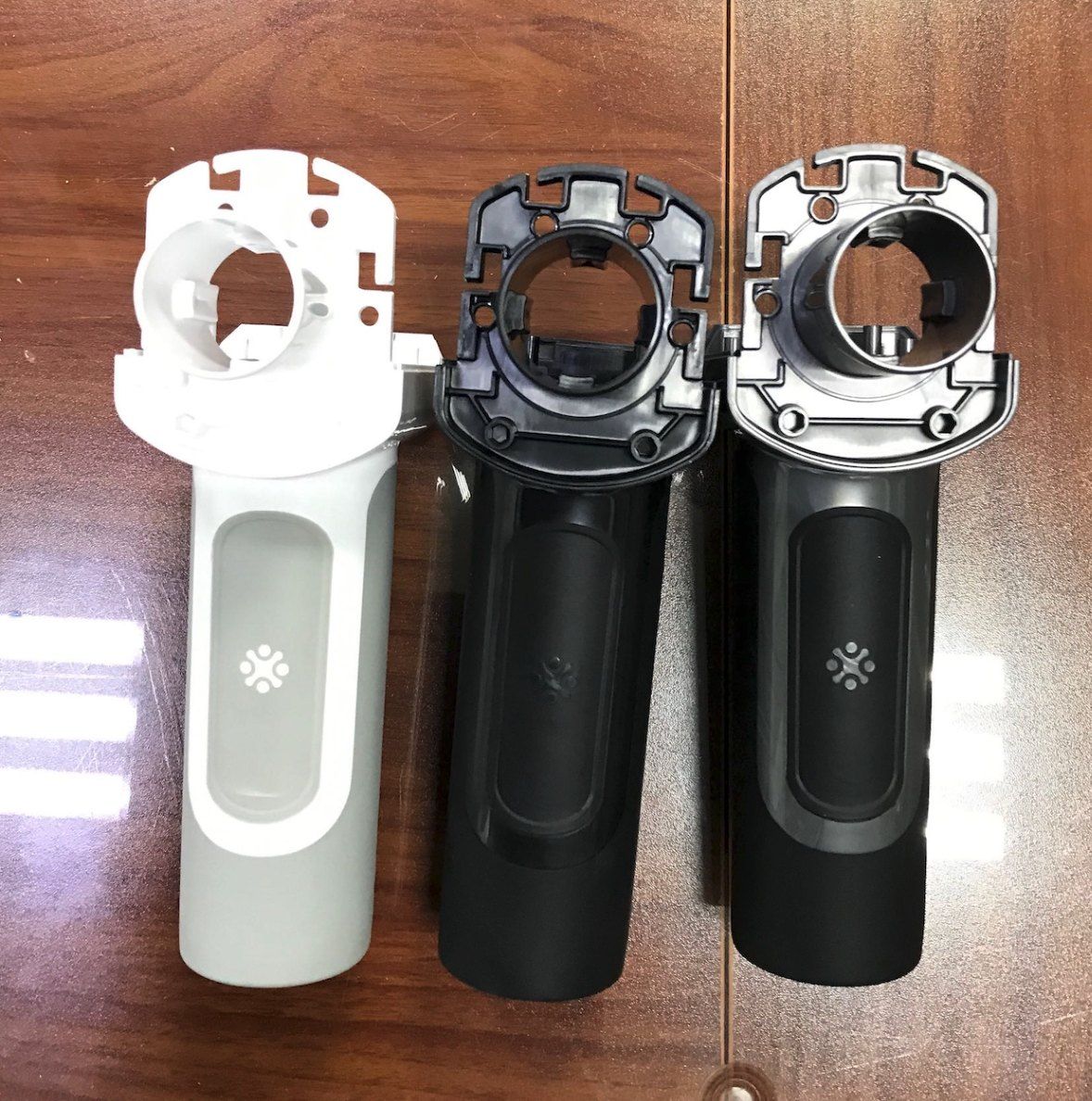 Three Vertigun housings side by side in white, black and grey.